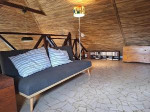 a couch in a room with a wooden ceiling at Exceptional house with sea view in Cap Skirring in Boukot Ouolof