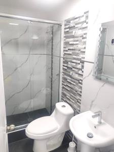a white bathroom with a toilet and a sink at El Polo Surco in Lima +4 photos