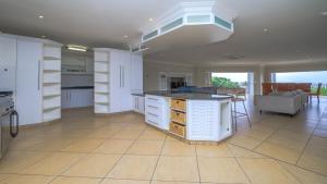 a kitchen with white cabinets and a table in it at Villa vasco in Ballito