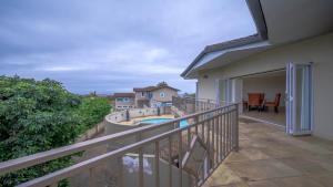 a balcony with a view of a swimming pool at Villa vasco in Ballito
