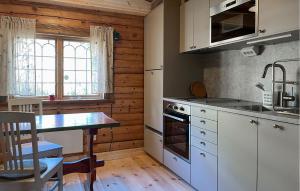 a kitchen with white cabinets and a table and a table sidx sidx sidx at Gorgeous Home In Sälen With Sauna in Sälen