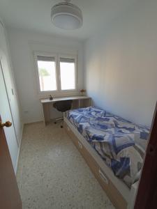 a bedroom with a bed and a desk and a window at Doña Cora in San Fernando +4 photos