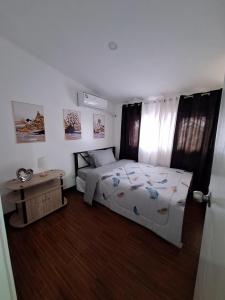 Un dormitorio con una cama y una mesa dentro. en Xevera Mabalacat Heart Staycation, en Mabalacat 9 fotos más