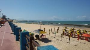 una playa con muchas sombrillas y gente en la playa en Apartamento incrível beira mar, en Natal