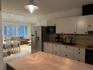 a kitchen with a refrigerator and a living room at Saukonkatu in Kokkola