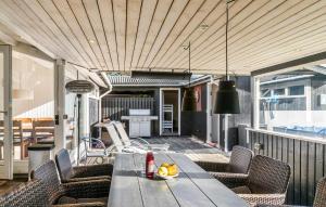 a wooden table on a balcony with chairs and a table at Three-Bedroom Holiday Home In Vaggerlose in Marielyst +13 photos