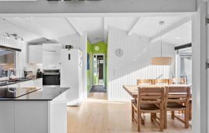 a kitchen and dining room with a table and chairs at Three-Bedroom Holiday Home In Vaggerlose in Marielyst