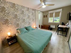 una camera con un letto verde e una parete di Chambres chez l'habitant Delphine et Guillaume a Venarey-les-Laumes