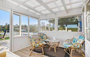 a porch with chairs and a table and windows at 2 Bedroom Nice Home In Haderslev in Haderslev