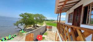 a balcony of a house with a view of the water at Cabaña Barbacoas in Santa Ana