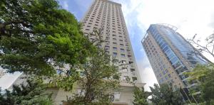 two tall buildings with trees in the foreground at TW Cyclinn Vila Olimpia in São Paulo