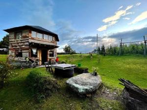 a small log cabin in a field with a rock at Eco-cabaña piemonte in Guasca