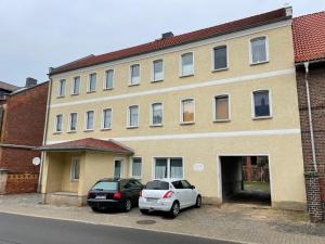 two cars parked in front of a building at CozyWork Apartment House in Hohenmölsen