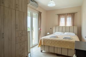 a bedroom with a bed and a large window at Palaiologou Panorama Apartments in Mantamádos +92 photos