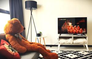 a teddy bear sitting on a couch in a living room at Spectacular city view Near Georgetown 9 pax in Jelutong