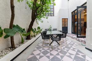 un patio con mesa y sillas en un suelo de baldosa en Casona y Loft Merida By Escajal Homes, en Ciudad de México
