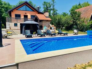 KapelaHarmony的房屋旁的游泳池配有椅子和遮阳伞