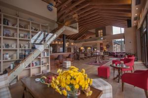 a lobby with a staircase and tables and chairs at Orizontes Tzoumerkon Hotel Resort in Pramanta