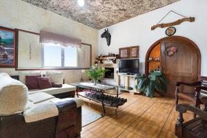 un salon avec un canapé et une table dans l'établissement Amazing Country House with Ocean View, Cueva de la Arena, à Garachico