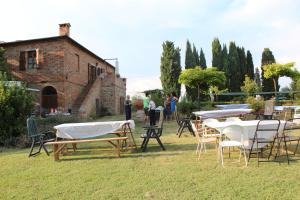 eine Gruppe von Tischen und Stühlen in einem Hof in der Unterkunft Agriturismo Santa Maria in Torrita di Siena