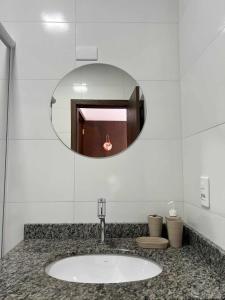 a bathroom with a sink and a mirror at Suíte Com Vista Privilegiada poucos minutos Vila Germânica Oktoberfest in Blumenau
