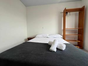 a bedroom with a bed with two towels on it at Suíte Com Vista Privilegiada poucos minutos Vila Germânica Oktoberfest in Blumenau