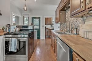 a kitchen with stainless steel appliances and wooden cabinets at City Oasis Awaits Cozy DT Home With Hot Tub Vikings in Minneapolis