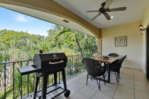 a grill on a balcony with a table and chairs at Garden Pool & 5-minutes Walk to Beach in Potrero