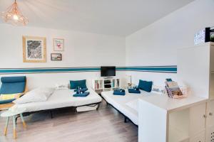 Dos camas en una habitación con almohadas azules. en Appartement du Rocher - 3 étoiles - Welkeys, en Biarritz