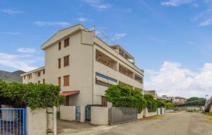 a white building with a fence next to a street at Lovely Apartment In Nocera Terinese in Nocera Terinese