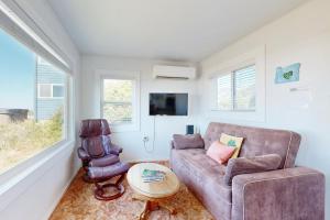 a living room with a couch and a chair at Breakers Cottage in Rockaway Beach