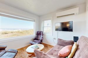 a living room with a couch and a window at Breakers Cottage in Rockaway Beach