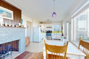 a kitchen with a table and a fireplace at Breakers Cottage in Rockaway Beach