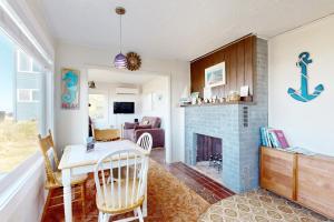 a living room with a table and a fireplace at Breakers Cottage in Rockaway Beach +23 photos