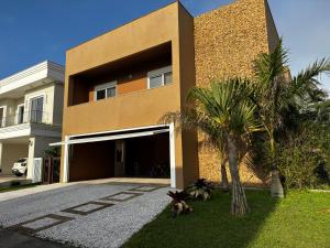 een gebouw met een garage en palmbomen ervoor bij Casa 450m2 Laguna Internacional in Laguna