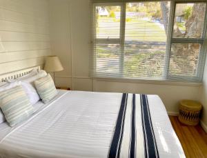 a bedroom with a large white bed with two windows at Halcyon Days in St Helens +10 photos