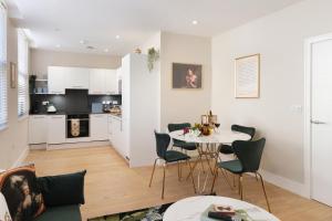 a kitchen and living room with a table and chairs at Dream Stays Bath - John Street Apartments in Bath