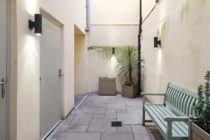 a hallway with a green bench and a plant at Dream Stays Bath - John Street Apartments in Bath