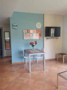 a table with chairs and a vase of flowers on it at Apartamento tosca mar con balcon 421 in Moraira