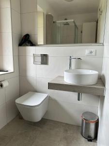 a bathroom with a toilet and a sink and a mirror at CASA VACANZE MIRAMONTI - appartamento con balcone con vista sulle Dolomiti in Borca di Cadore +18 photos
