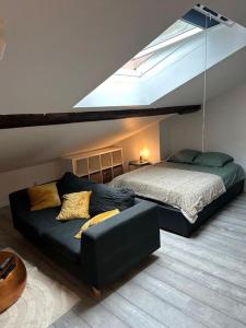 une chambre avec un lit et un canapé dans un grenier dans l'établissement Studio Metz centre & gare, à Metz