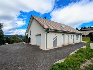 AnouldGîte chêne的一栋白色建筑，车道上有一个车库