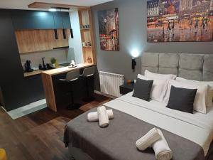 a bedroom with a large bed with towels on it at Alex lux apartman in Kragujevac +50 photos