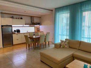 a living room with a couch and a table and a kitchen at Sunny Villa in Byala