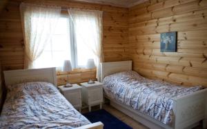 sypialnia z 2 łóżkami w drewnianym domku w obiekcie Salkolahti Lomamökit w mieście Längelmäki
