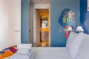a bedroom with a white bed with a blue wall at Boutique Apt in the Heart of Auckland Zodiak Stays in Auckland +15 photos