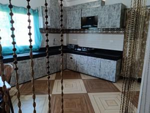 a room with a staircase with a kitchen in the background at Areca Holiday Apartment in Siliguri