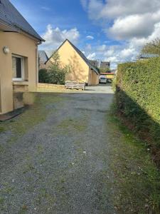 a driveway of a house with a yellow building at Honey Room22 , parking, proche gare in Saint-Brieuc