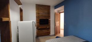 a kitchen with a white refrigerator in a room at Loft 02 in Bombinhas