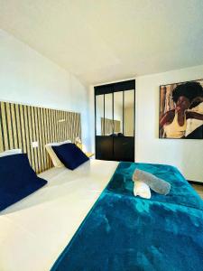 a bedroom with a large bed with a blue blanket at Sweety blue, vue mer in Les Trois-Îlets